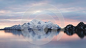 Colorful sunset in the Norwegian fjords. Cruise to Trollfjord. Snowy mountains of Lofoten Islands. Sailing in Trollfjord