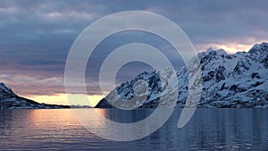Colorful sunset in the Norwegian fjords. Cruise to Trollfjord. Snowy mountains of Lofoten Islands. Sailing in Trollfjord