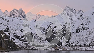 Colorful sunset in the Norwegian fjords. Cruise to Trollfjord. Snowy mountains of Lofoten Islands. Sailing in Trollfjord