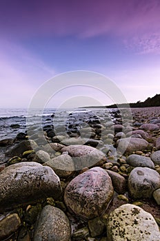 Colorful sunset over the boulders on the beach, Sweden