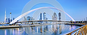 colorful sunset over Dubai Downtown skyscrapers and the newly built Tolerance bridge as viewed from the Dubai water canal