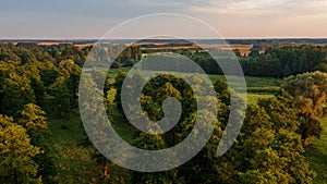 Colorful sunset over forest and fields aerial