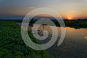 Colorful sunset over the river suburban area of central Russia