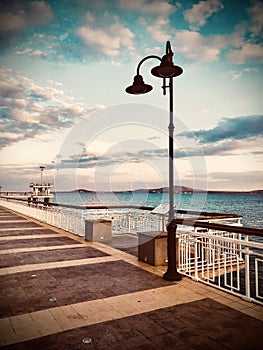 Colorful sunset over the sea bridge in Burgas bay, Bulgaria. Black Sea landscape. Vintage filter