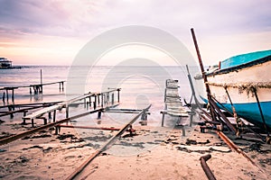 Colorful sunset over the sea shore. Old rusty boat berths. Long exposure smooth water waves effect