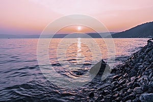 Colorful sunset on a rocky beach, late summer evening