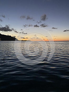 Tropical sunset over South Pacific Ocean in Moorea, French Polynesia from sailing catamaran