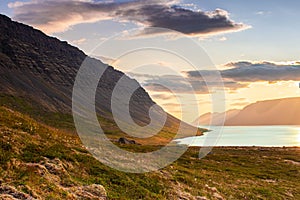 Colorful sunset by the sea at the fjords with dawn, beautiful bay, cloudy sky, Iceland