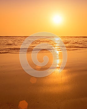 A colorful sunset or sunrise on the seaside with a sandy beach with impurities of volcanic ash. Mandrem, Goa, India