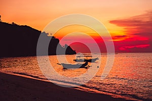 Colorful sunset in tropical island, beach and local boats in Bali