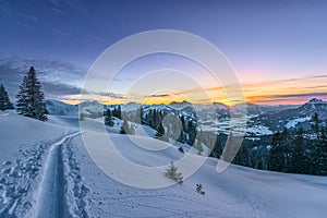 Colorful sunset view from ski track on snowy filed