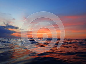 Colorful surface with vivid colors of sunset and night reflection before commencing of night dive.