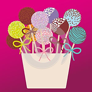 Colorful Sweet Cake pops set with bow in a pink bucket on dark pink background.