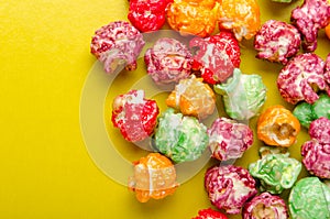 Colorful sweet popcorn on yellow background. Delicious treat for children.