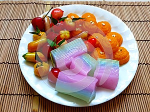 Colorful sweet Thai desserts on bamboo mat, such as Deletable Imitation Fruits (Khanom Look Choup),