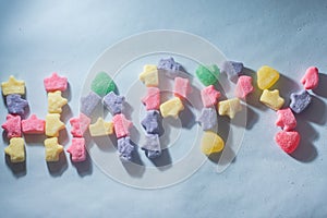 Colorful sweets varied with the word "Happy" written,light blue background,children's concept and joy