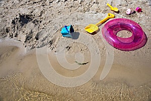 Colorful swim ring life buoy, bucket and shovels on the beach