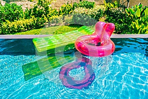 Colorful swim ring or rubber float around swimming pool water