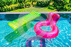 Colorful swim ring or rubber float around swimming pool water