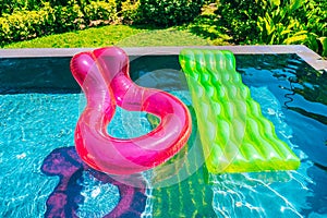 Colorful swim ring or rubber float around swimming pool water