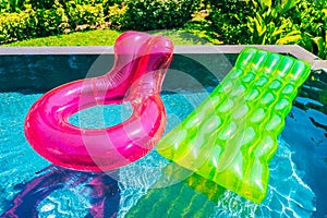 Colorful swim ring or rubber float around swimming pool water