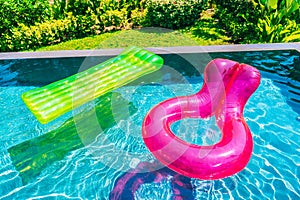 Colorful swim ring or rubber float around swimming pool water