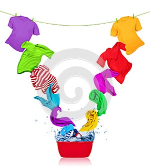 Colorful t-shirts flies out of the laundry bowl