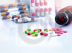 Colorful tablets and capsule pills on blurred background of drug bottle and antibiotic capsule pills. Pharmaceutical industry.