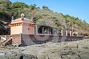 Colorful temple of goddess Uma Maheshwari on rocky shore photo