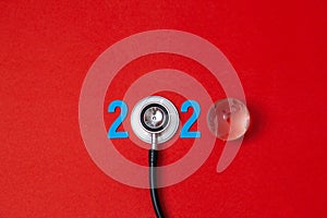 Colorful on text 2020 banner for health care and gobal medical concept. black stethoscope,on table red background photo
