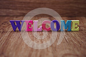 Colorful text welcome letters alphabet on wooden background