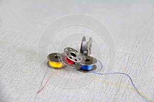 Colorful thread in the bobbins, red yellow blue and white color put on the Sewing machine.