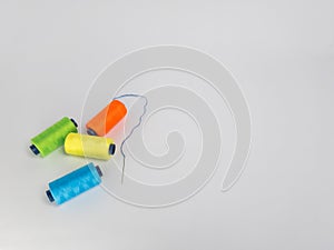 Colorful Thread Spools Arranged on a Plain White Surface for Crafting
