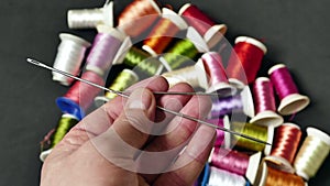 colorful thread wound bobbins, large needle and small sewing needle, classic manual sewing needle