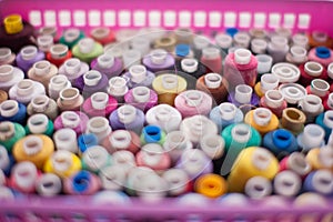 Colorful threads on a shelf at a sewing workshop, close-up