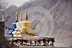 Colorful three stupa or chedi in Maitreya Buddha statue and Diskit Monastery perched against the hills at nubra valley village