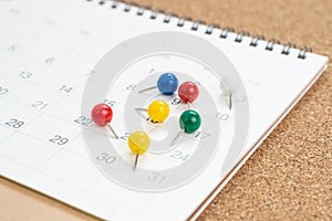 Colorful thumbtack, pushpin or pins on calendar concept for busy meeting schedule, reminder or special event and important