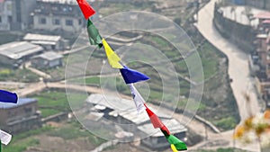 Colorful Tibetan prayer flags flutter ancient prayers into serene wind over Kathmandu city