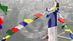 Colorful Tibetan prayer flags flutter ancient prayers into serene wind over Kathmandu city