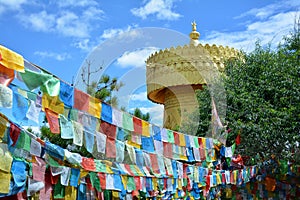 Colorful tibetian flags and biggest buddhist wheel in the world