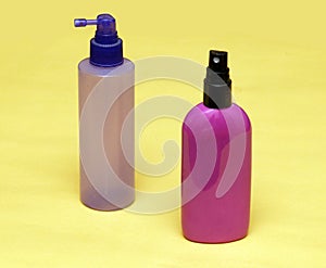 Colorful toiletries sprays on yellow