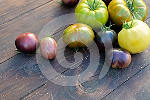 Colorful tomatoes of different varieties on a brown wooden table