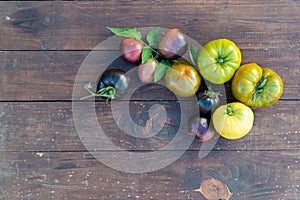 Colorful tomatoes of different varieties on a brown wooden table