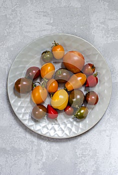 Colorful tomatoes on the grey surfase