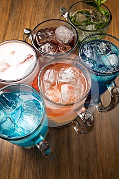 Colorful toned cocktails on wooden background. Frutal alcoholic cocktails. Colorful drinks concept