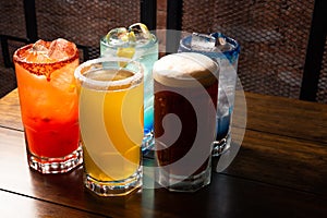 Colorful toned cocktails on wooden background. Frutal alcoholic cocktails. Colorful drinks concept on wooden table