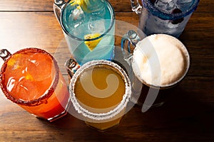 Colorful toned cocktails on wooden background. Frutal alcoholic cocktails. Colorful drinks concept on wooden table