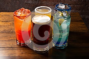 Colorful toned cocktails on wooden background. Frutal alcoholic cocktails. Colorful drinks concept on wooden table