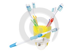 Colorful toothbrushes in cup with dental floss