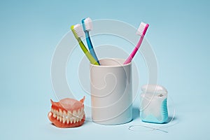 Colorful toothbrushes, dentures and dental floss.